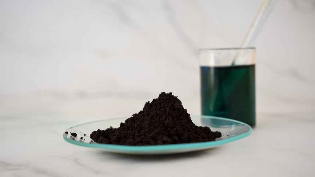 green oil dye powder with glass beaker in background