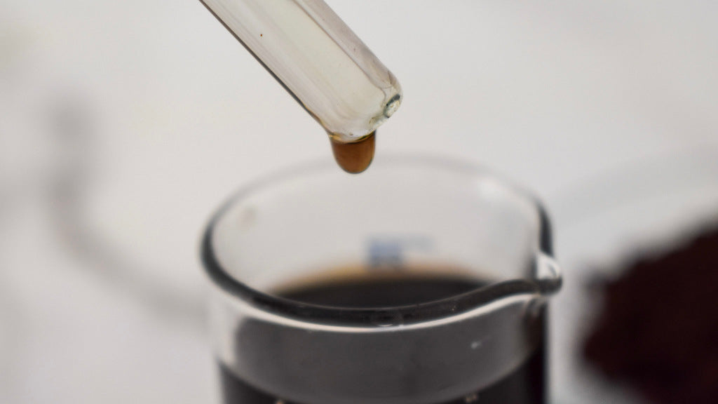 brown oil dye drop in glass beaker