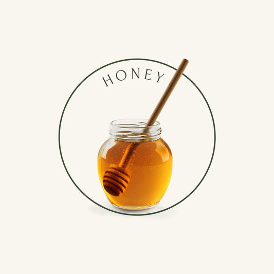 Honey jar with spoon on beige background