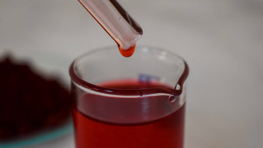 red oil dye drop in glass beaker